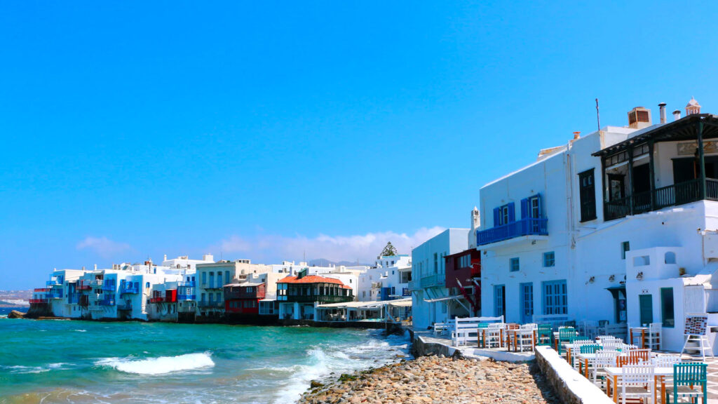 View of a serene beach with beautiful buildings in the background, basking in the sunlight